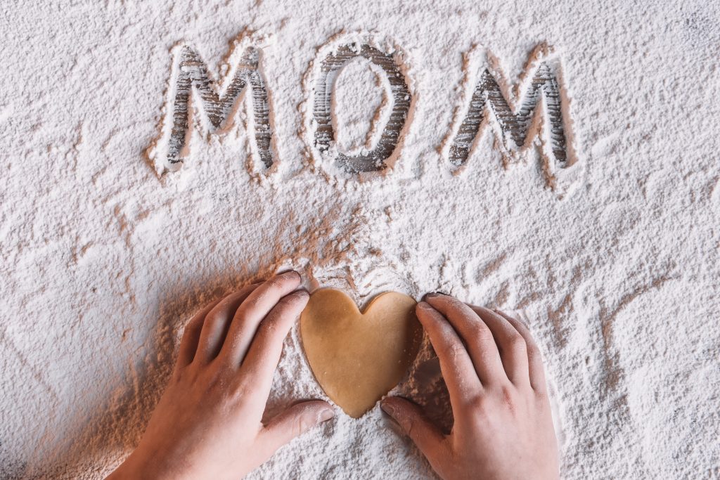 The word mom written in cake flower with a heart made of dough. 