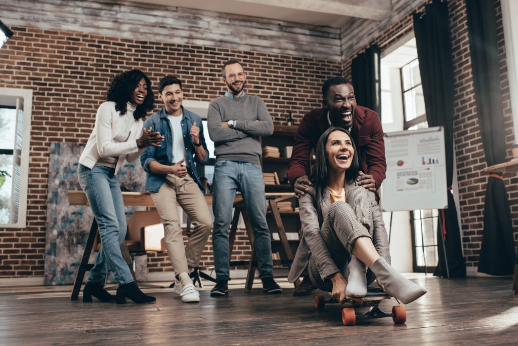 Corporate event ideas: a group of colleagues having fun in the office. 